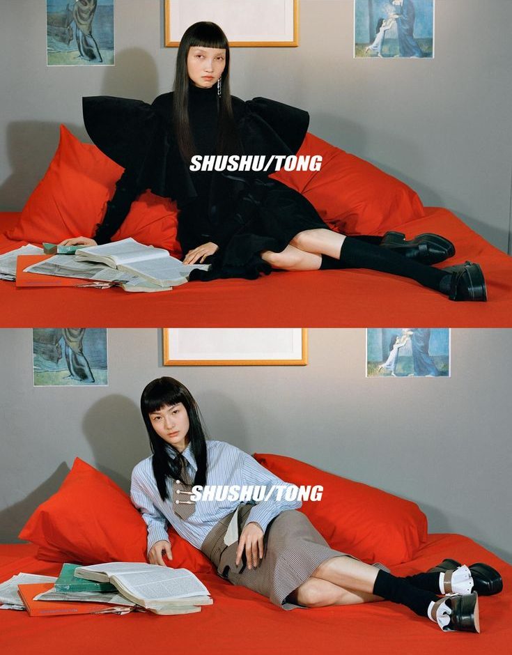 Two models showcasing Shushu/Tong's Autumn/Winter 2018 collection, featuring avant-garde feminine designs, bold silhouettes, and tailored aesthetics in a stylish indoor setting.