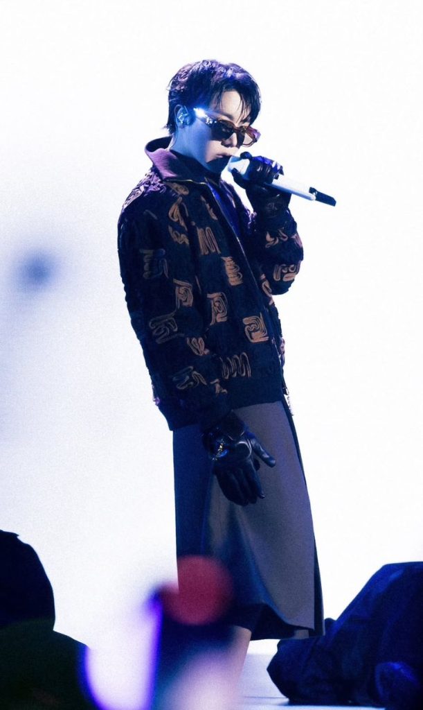 J-Hope performing at Gala des Pièces Jaunes 2023 in Paris, wearing designer fashion and sunglasses, representing BTS on a global stage.