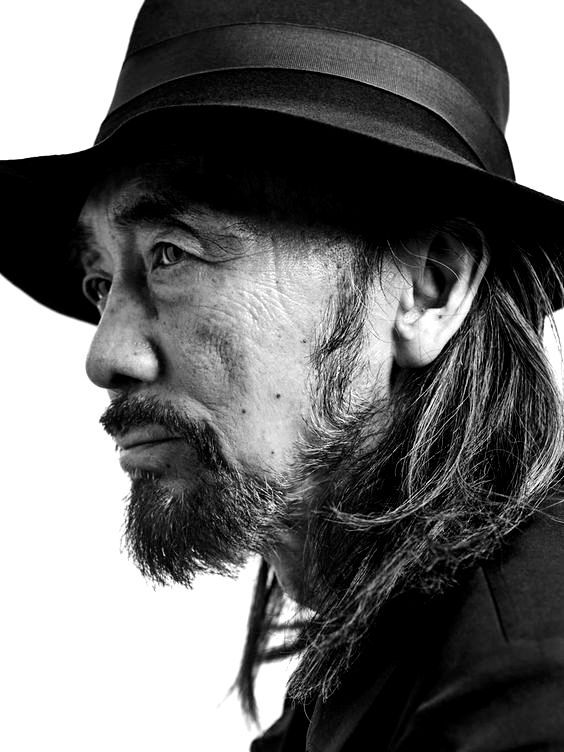 Black-and-white close-up portrait of Yohji Yamamoto wearing a signature fedora, reflecting his timeless style and status as a global fashion icon.