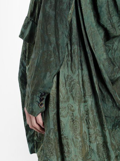 Close-up of Uma Wang green jacquard Kanti jacket showing rich floral texture and draped construction with minimalist sleeve detailing.