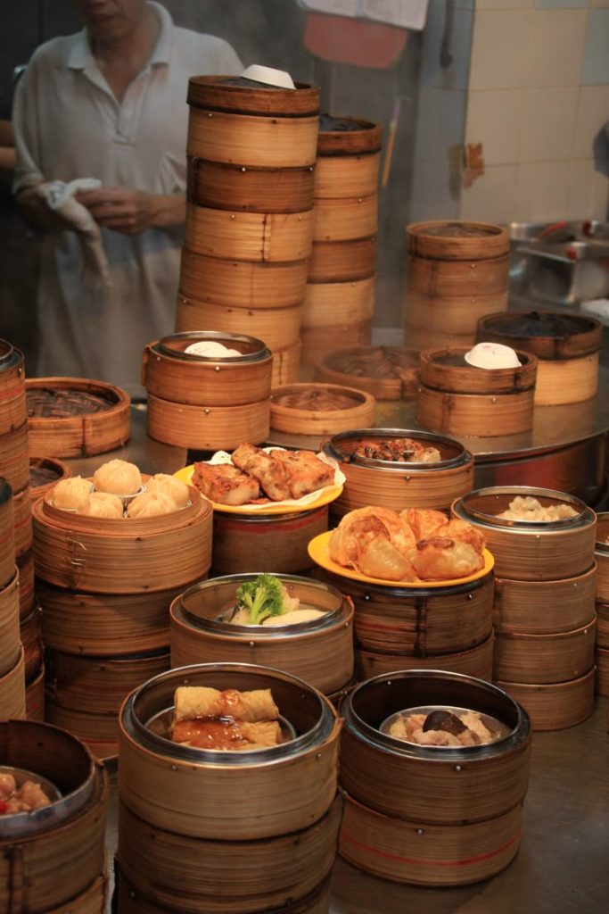 Traditional dim sum steamers with various Cantonese dishes at a Hong Kong street food stall